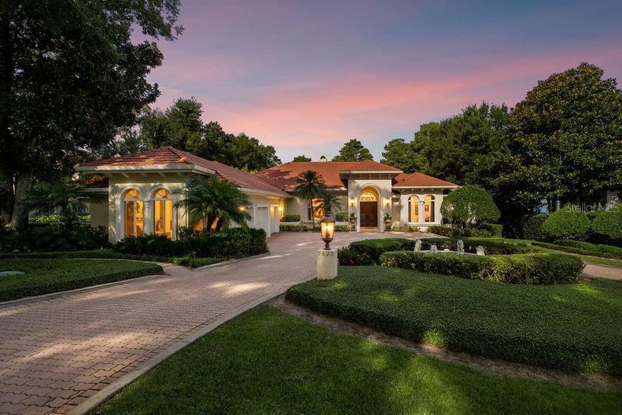 Tucked within the gates of Isleworth Golf Community and Country Club lies a residence that feels more like a private lakeside retreat than a home. Here, more than 7,000 square feet of elegance unfolds across a premium homesite on the shores of Lake Butler, where the water is clear, the sandy beach is pristine, and the sunsets spill across the horizon in dazzling color every evening.

The moment you step inside, the story begins with a grand foyer — ceilings soaring high above, delicate moldings tracing every line, and crystal chandeliers casting a warm, inviting glow. From there, each room flows gracefully into the next: a formal living space framed by expansive windows that draw your eye to the lake beyond, a dining room designed for unforgettable evenings, and a gourmet kitchen where Thermador appliances, custom cabinetry, and a sweeping center island invite both culinary creativity and casual gatherings.

In the heart of the home, the family room blurs the line between indoors and outdoors. Every doorway leads you to the balcony — a stage for sunset cocktails, laughter with friends, or quiet moments with only the water and sky for company.

Practicality pairs with luxury here. A secondary full kitchen and laundry create ease for multigenerational living or long-staying guests. A private office offers focus, while a gym inspires wellness. And for peace of mind, the home is equipped with its own backup generator.

Step outside, and the lifestyle becomes unmistakably Floridian. A screened patio and summer kitchen spill into a resort-style pool with waterfall and spa, all positioned to gaze over the lake. Down by the water’s edge, a private dock unlocks the entire Butler Chain — endless afternoons of boating, fishing, or watersports at your doorstep.

This is not simply a house, but a canvas of experiences. Every sunrise and sunset, every gathering and quiet escape, is framed by the natural beauty of Lake Butler and the sophistication of Isleworth. It is Florida living at its most refined — where elegance meets ease, and the lake is always the backdrop.