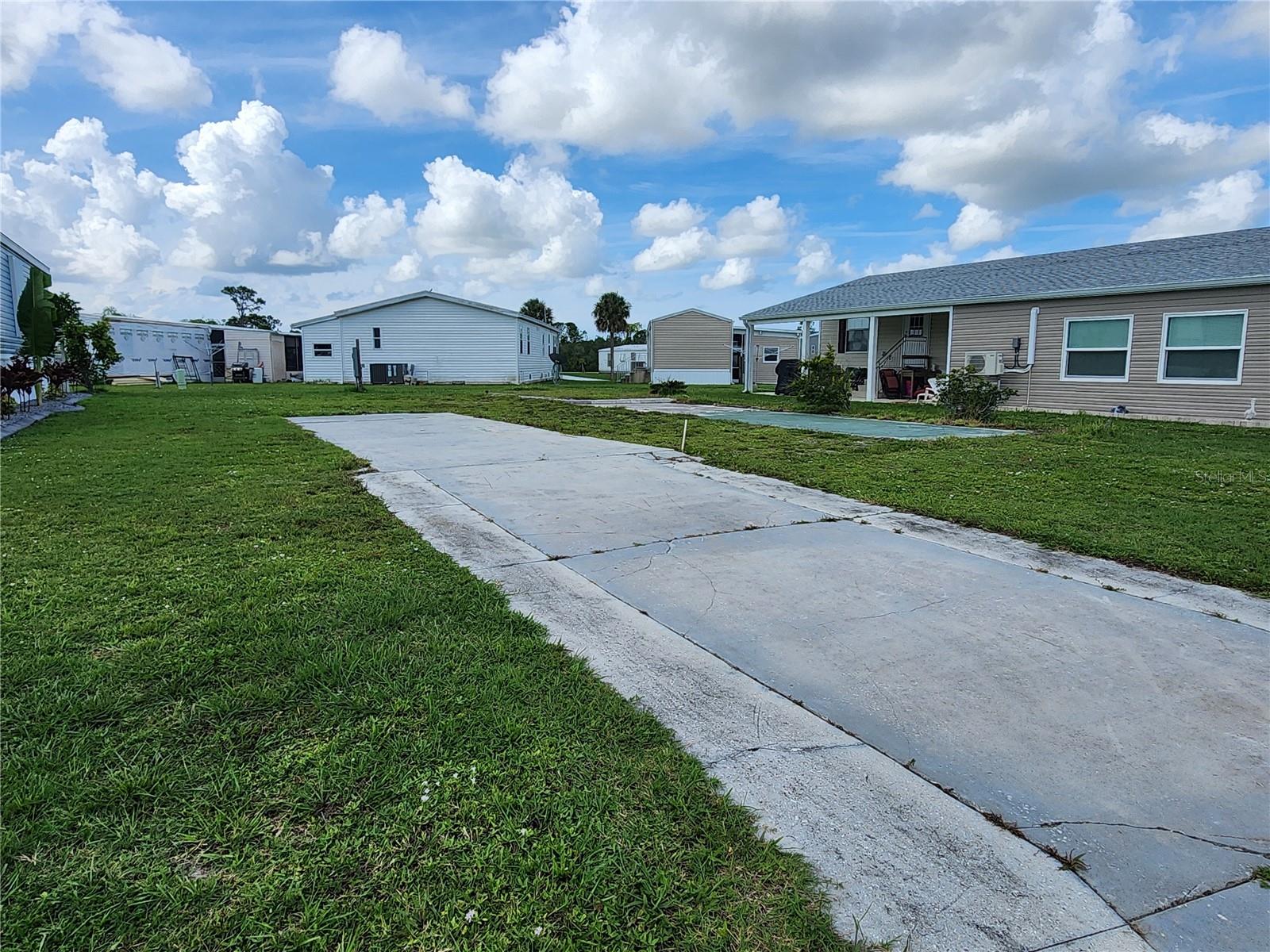 LARGE ENOUGH FOR A DOUBLE WIDE PLUS A CARPORT AND SHED! New 200 AMP main breaker meter panel. Conveniently located on the first street within the community - and only a few lots down the street from the TWO LARGE POOLS & RECREATION CENTER. This property also affords you a VIEW OF THE LAKE across the street. In addition, the neighbors are friendly and will welcome you to the park right away. Tucked away - yet close to everything - VHL is a wonderful, GULF ACCESS community with a BOAT RAMP, fishing pier, and boat slips. GROUNDS MAINTENANCE is included in the low monthly fee. Here you can be as social as you'd like with its many activities such has horseshoe tournaments, block parties, woodworking, billiards, pot luck dinners, and so much more! Both full-time residents and snowbirds love to call Village of Holiday Lake home. Come check it out for yourself today.