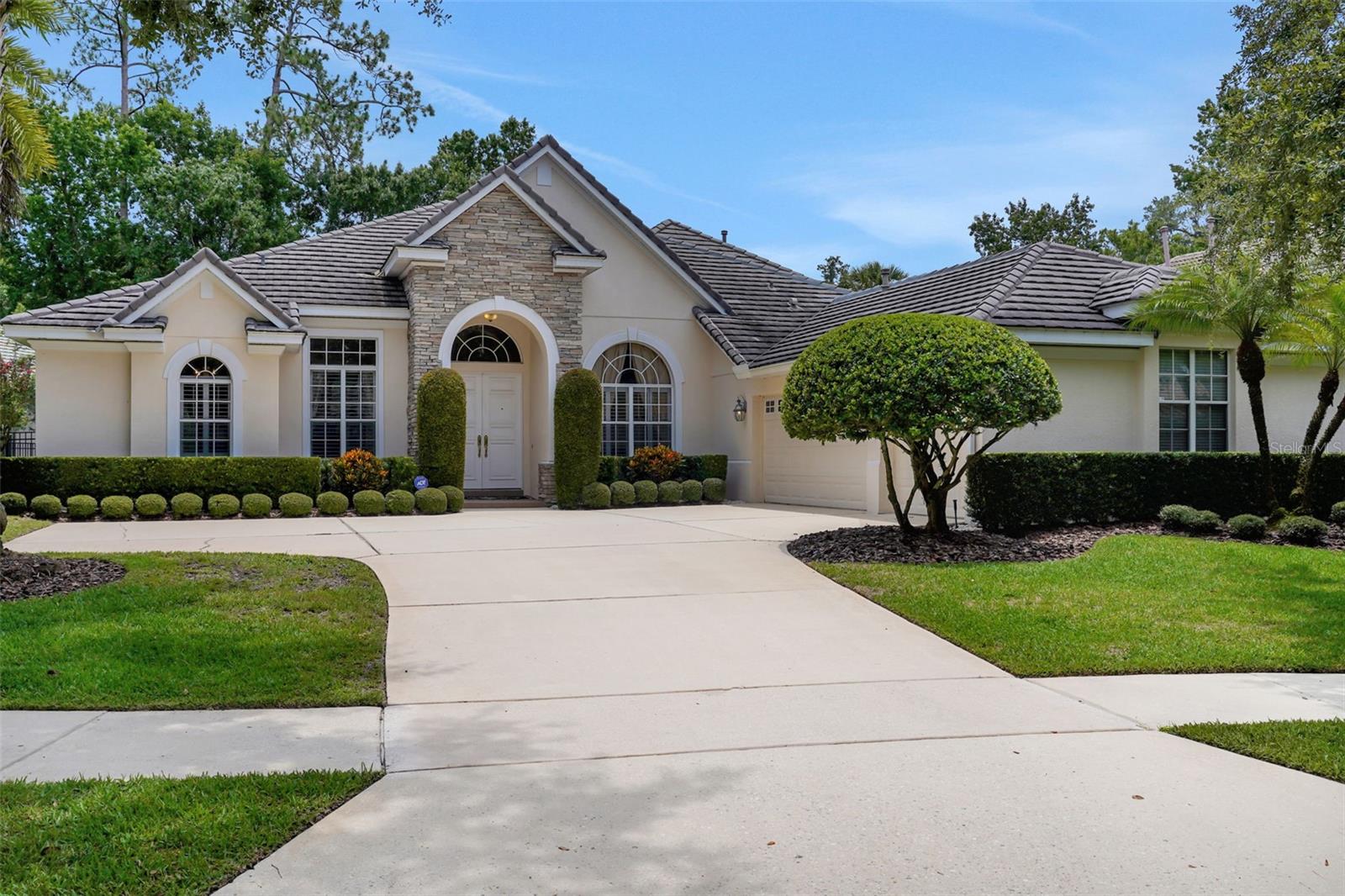 Stunning oversized and customized "Estancia" model featuring 5 bedrooms, 4.5 bathrooms, a private study, and a spacious bonus room—ideally positioned along the 7th tee of the exclusive Legacy Club Golf Course at Alaqua Lakes, offering partial views of lush conservation and the fairway from your large fenced-in yard. This nearly 3,800 sq. ft. home is mostly single-story living, with the 5th bedroom/bonus room being the only upstairs space. Enjoy expansive living areas, including an oversized family room and generously sized secondary bedrooms with spacious closets. The kitchen boasts rich 42” cherry cabinetry, natural gas cooktop, and copious storage and prep space, while neutral paint throughout adds a fresh touch. The living room features a cozy gas fireplace with a striking stone surround. Elegant touches include extensive crown molding, plantation shutters on the main level. Step outside to your private backyard retreat, where a dark-bottom, self-cleaning pool and spa with waterfall create a tranquil garden oasis overlooking the course. Entertain effortlessly poolside in this truly picturesque setting. An oversized 3 car garage bookends the many features of this wonderful home, ensuring storage of all of life's incidentals. As a resident of Alaqua Lakes, you'll have access to a unique 7-acre community park with an open-air pavilion, multipurpose field, tennis courts, and more—all just minutes from top-rated schools, upscale shopping, dining, business centers, and major highways. This property may be under audio/visual surveillance.