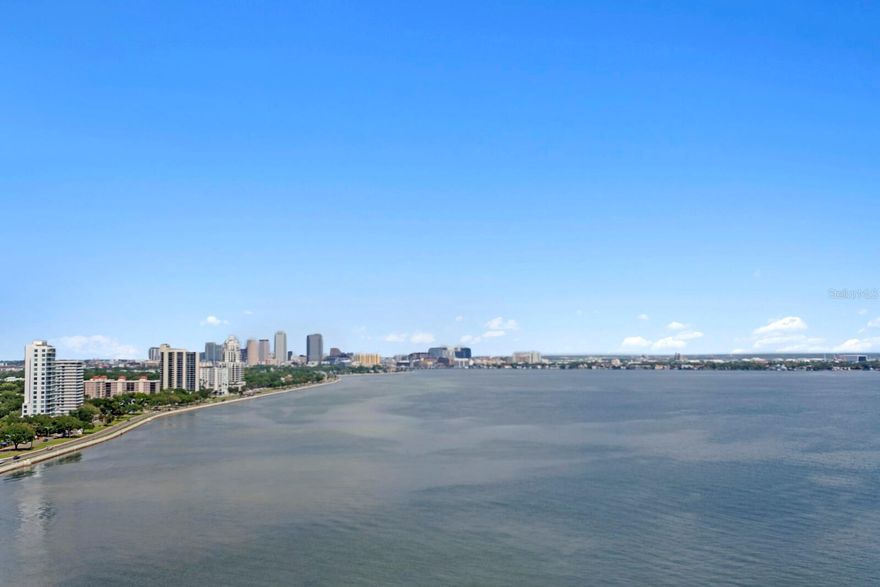 Welcome to the pinnacle of luxury living on the iconic Bayshore Boulevard! Balcony Unit designed by renowned interior designer Tommy Lamb, this extraordinary sky-high residence spans over 4,100 SF on the 22nd floor, offering unobstructed, panoramic views of Tampa Bay, Hillsborough Bay, and Downtown Tampa. This fully customized 4 bedroom, 4.5 bath home seamlessly combines two units into one breathtaking masterpiece where no detail has been overlooked. Step off your private elevator into the beautiful foyer and experience rich wood floors with porcelain tile inlay, setting the tone for the exceptional craftsmanship throughout. The expansive living space features floor-to-ceiling windows, a custom wet bar, and sweeping views—perfect for entertaining. The chef’s kitchen is a showstopper, featuring Italian cabinetry, a 96-bottle wine display, walk-in pantry with prep sink, and premium Wolf and Sub-Zero appliances. A hidden butler’s pantry, two wet bars, and a formal dining room that comfortably seats 12 elevate your hosting game. The luxurious primary suite includes a private balcony, spa-inspired bath, and a massive custom closet with water views. All guest suites offer en-suite baths and stunning vistas. Additional features include smart home automation, custom lighting, electronic roller shades, vanity mirror TV, and bespoke closets throughout. Enjoy the convenience of 3 dedicated parking spaces, a private storage unit, and a climate-controlled storage cage. Monte Carlo Towers offers resort style amenities: a 24,000 SF marble lobby, 24-hour concierge, two guest suites, heated pool, grilling area, social room with commercial kitchen, library, fitness center with saunas, and tennis/pickleball courts. Located in a top-rated school district and just minutes to Downtown, Hyde Park, SOHO, Riverwalk, and Tampa International/St. Pete Clearwater Airports, easy access to major highways, including I-275, I-4, and the Selmon Expressway with the nation’s longest continuous sidewalk right outside your door. Experience elevated living at its best—schedule your private tour today!
