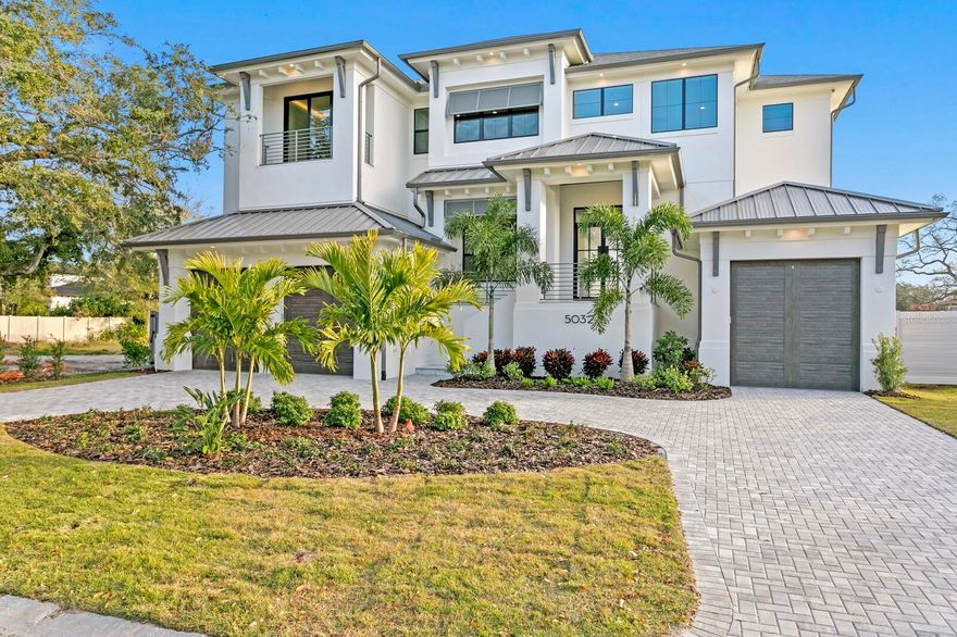 New-Completed Construction. Modern Coastal home in Sunset Park showcasing exceptional design, craftsmanship, and attention to detail throughout. The St. Lucia Model by Taralon Homes presents elevated coastal living with potential water views and stunning sunsets from the second-floor sundeck on this uniquely positioned lot. A circular drive and custom coach lighting lead to a custom iron front door and impressive two-story foyer. The grand living room features tiered ceilings and a fireplace, adjacent to a formal dining room and an open kitchen overlooking the family room and infinity pool beyond. The gourmet kitchen is ideal for entertaining, equipped with Thermador appliances, wine and beverage refrigeration, microwave drawer, integrated Scotsman ice maker, 42-inch maple cabinetry with upper glass doors, center island, quartz or granite counters, and a pot filler. The first level also includes an en-suite guest room, powder bath, and laundry/utility area with maple cabinetry, quartz or granite counters, and laundry sink. Upstairs, the game/flex room offers a tiered ceiling, hardwood flooring, and terrace access, along with additional en-suite guest rooms and an upper-level laundry room. All guest rooms feature hardwood flooring, walk-in closets, and designer baths with maple cabinetry, quartz or granite counters, and semi-frameless shower enclosures. A double-door entry leads to the primary retreat with potential water views, tiered ceiling, dual closets, terrace access, and a spa-inspired bath with shiplap accents and dual vanities. Outdoor living features a heated infinity-edge pool and spa, covered lanai with tongue-and-groove wood ceiling, fireplace, summer kitchen, cabana roof deck, pool bath, and open patio with natural-gas firepit. Additional highlights include naturally aged Medallion Collection wood flooring throughout, a three-stop elevator, 7-inch crown and baseboards, dual laundry rooms, and a three-car garage with steel Canyon Ridge carriage-style doors. The home offers Low-E impact-rated windows and doors. Enjoy the best of South Tampa living—minutes from Downtown Tampa, International Plaza, Tampa International Airport, and area beaches—with highly regarded schools, tree-lined streets, and exceptional lifestyle convenience.