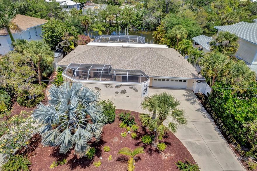 Indulge in the ultimate luxury living experience on Siesta Key by stepping right into your dream home, where the wonders of this sought-after destination will envelop you. Located in the highly coveted Palm Island community, this stunning canal front property is the epitome of sophistication and class. With its prime location, it caters to every lifestyle, whether you're a beach lover, a boating enthusiast, or a nature admirer. Just a short distance away, you'll find the famed Siesta Beach (Beach Access 10) and the lively Siesta Key Village, where a plethora of dining, shopping, and entertainment options await. As you enter this immaculately maintained island residence, you'll be greeted by fresh landscaping and a circular driveway that sets the tone for the exquisite waterfront oasis that awaits you. The well-designed floor plan boasts a spacious living room at the front and a cozy family room at the back, both seamlessly connected and perfect for both functionality and style. The tile flooring throughout adds a touch of elegance, while the kitchen features granite countertops and stainless steel appliances that are only a few years old. Retreat to your very own owner's suite, complete with a walk-in closet and an en-suite bathroom featuring dual sinks and a glass enclosure shower. The two guest bedrooms are equally charming, each with its own exit to the courtyard and lanai, allowing for seamless indoor-outdoor living. The screened-in lanai, surrounded by travertine tiles, is the ultimate spot for summer entertaining, providing a touch of sophistication that complements the luxurious ambiance of this home. And let's not forget about your boat! This stunning home features a 10,000lb boat lift, with a brand new seawall in the process of being installed. Plus, you can rest easy knowing that a new roof was recently installed in 2020 over the pool area and 2021 over the main residence. Come and experience the ultimate in luxury living on Siesta Key, where every day feels like a vacation in your very own idyllic sanctuary. BE SURE TO CHECK OUT THE PROFESSIONAL VIDEO TOUR: https://vimeo.com/822073442