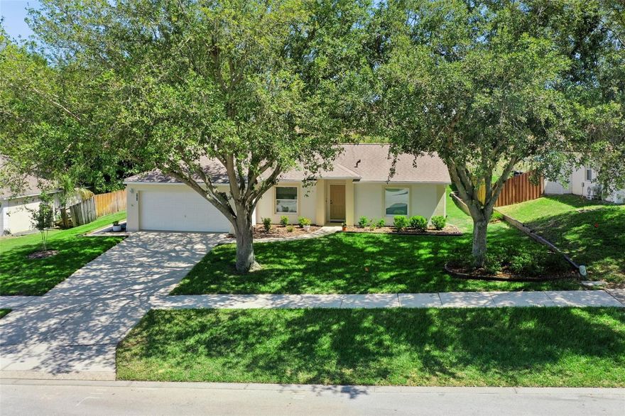 Welcome to a beautifully maintained three-bedroom, two-bath home on a well-manicured quarter-acre-plus lot in the rapidly growing city of Minneola. Gorgeous mature trees frame the home and create a welcoming first impression while providing shade and character to the property. The partially fenced yard offers plenty of space for outdoor enjoyment, gardening or pets, and reflects pride of ownership seen throughout the entire property. Inside, the home is immaculate and move-in ready. From the moment you go through the door, it is clear how well this home has been cared for. There is nothing to do but bring your belongings and settle in. The spacious great room plan creates an open and comfortable living area that easily connects to the kitchen and dining spaces, making it ideal for everyday living or entertaining. A formal dining area is available if desired, while the kitchen also offers a generous eat-in area for casual meals and everyday gatherings. The primary bedroom provides a relaxing retreat with a walk-in closet and peaceful views overlooking the backyard. The en-suite bath features a walk-in shower and a practical layout designed for comfort and convenience. Ceiling fans throughout the home help keep every room comfortable year-round. Go outside to the inviting 10-by-10-foot covered and screened lanai with glass windows, a wonderful space to enjoy morning coffee, quiet evenings, or simply relax while looking out over the backyard and beautiful trees. The attached two-car garage with door opener provides additional storage and everyday convenience. In the growing city of Minneola, this home places you close to everything that continues to make the area desirable. New restaurants, a brewery coming soon, the new Florida Turnpike exit and recently opened hospital are all nearby, making this location especially convenient for those working in the area. It is an ideal home for employees looking to live close to the new medical campus while enjoying the comfort of an established neighborhood. With its immaculate condition, spacious lot, beautiful trees and move-in-ready appeal, this home offers an incredible opportunity at an amazing price in one of Central Florida’s exciting and growing communities.