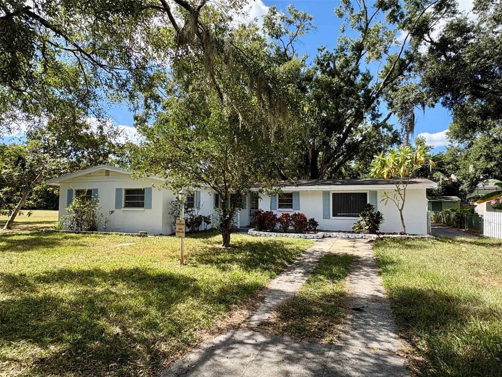 Located in the heart of Lake Magdalene, this property offers a rare non-subdivision setting with no deed restrictions. The 0.28-acre lot features mature oak trees providing shade and character. The home, built in 1956, is solidly constructed but retains its original finishes and is ready for updating. A large screened porch adds usable outdoor space. Out back, a detached two-car garage provides excellent storage or workshop potential. Priced below market to reflect its condition. Convenient to I-275, restaurants, and shopping.