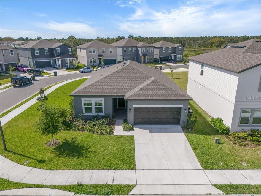 One story single family home on an oversized corner lot in one of Davenport's most desirable neighborhoods and resort-style living in Champions Gate. The modern interior features elegant ceramic plank tile flooring throughout, creating a seamless and stylish look.  The gourmet kitchen boasts 42-inch cabinets providing ample storage, along with luxurious quartz countertops, stainless steel appliances - perfect for entertaining and daily living. 2-car garage. The property offers privacy and additional outdoor space, with a generously sized lot ideal for relaxation and activities. Conveniently located with easy access to the Enclaves Amenity Center, offering shopping, dining major highways, and just minutes from world-class theme parks and attractions.