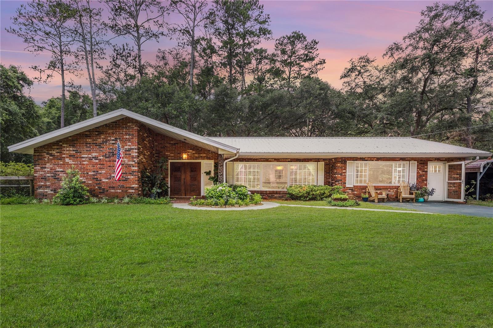 Charming 4BR/2.5BA all-brick country retreat on 1.11 acres! Escape the hustle and bustle and embrace peaceful country living with this beautifully updated home in Williston. Featuring a spacious layout with four bedrooms and two and a half baths, this property offers room for the entire family and the freedom to enjoy your land without HOA restrictions. Step inside to discover a fully remodeled kitchen boasting modern finishes, ample storage, and thoughtful details—perfect for gathering with loved ones or entertaining guests. The inviting open floor plan features a generous living room ideal for both relaxation and entertaining, complemented by natural light. A cozy back porch invites you to unwind, while the carport adds convenient covered parking. Outside, you'll find mostly fenced-in land, ideal for adding a pool, orchard, or garden—let your imagination run wild! The property even features its own streetlight, providing a welcoming glow at night. Recent updates enhance peace of mind and efficiency, including a generator transfer switch (2024) for reliable backup power, new electrical panel (2023), new drain field (2024), new water heater (2025), a metal roof approximately 10 years old, and an A/C unit installed in 2019. With plenty of room to roam and charming green pastures nearby, this property offers the perfect blend of privacy and convenience. Ideally situated just less than five minutes from downtown Williston, about 22 minutes from Gainesville, and approximately 25 minutes from Ocala, you’ll enjoy easy access to shopping, dining, and amenities. Room dimensions and school information are approximate; buyers are encouraged to verify. Home is on a well and septic system. Don’t miss the opportunity to own this serene country escape with no HOA—call today to schedule your private tour!