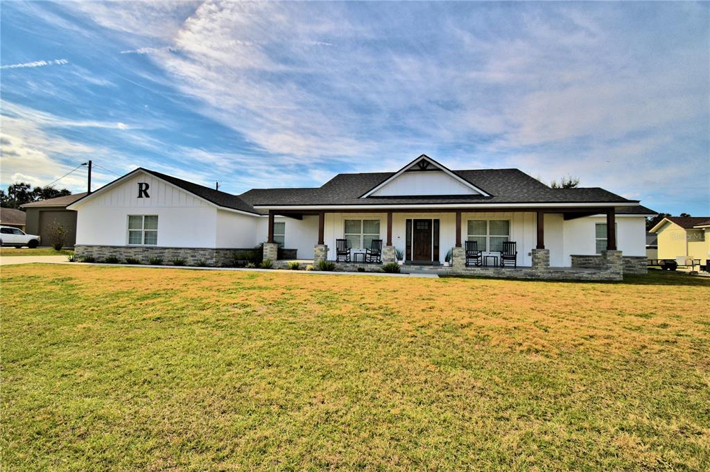 Located in Auburndale, this Beautiful Craftsman Style Home was built in 2021. With over 3200 sf of living area, this Pristine Home features 6 bedrooms, 3 full bathrooms and a 3-car garage which includes a Separate Storage Room. The Sprawling Front Porch Welcomes Warmly and Gives a Sneak Peak of what's to Come when Entering the Home. The Large Formal Foyer leads to the Common Area of the Home where you will appreciate the Open Concept Floor Plan giving excellent flexibility for entertaining or cooking without feeling Cut Off from the Rest of the House. The Kitchen has Gorgeous Granite Countertops, Loads of Wood Cabinets, A Large Island, Stainless Appliances and a Walk-In Pantry that is sure to be the Chef's Dream. The Living Room features a cozy Fireplace adorning a Stone-Clad and Board & Batten surround which is the Focal Point of the room. This Open space also includes the Dining Room which provides plenty of space for Large Family Gatherings and Dinner Parties. Just off the kitchen and down the hallway you have access to the primary suite with a 15 x 18 bedroom featuring a tray ceiling & an enormous custom designed walk-in closet and en-suite with dual vanities, a soaker tub, a walk-in Shower with Dual Shower Heads and Stunning Tile Work. Just down another hallway, there is a bedroom, a full bathroom, laundry room, a tastefully designed Drop Zone and leads to the 3 Car Garage. Off of the living room is another hallway where there is a large storage closet, 3 bedrooms and a full bath. To the left of the kitchen is an office which can also be used as the 6th bedroom or flex space. The main areas of the home feature luxury vinyl planked floors and carpeting in each bedroom. The 22 x 11 lanai overlooks the large back yard where there is plenty of room to add a pool or a workshop. Located close to the Polk Parkway, you have easy access to restaurants, shopping, medical facilities and entertainment. Call today for your private tour and be prepared to be impressed.