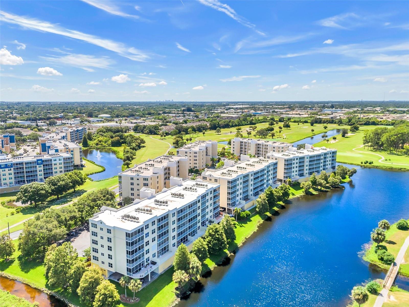 One or more photo(s) has been virtually staged. Welcome to Building Six at Country Club Condominiums, a highly sought-after golf course community located along the beautiful East Bay Golf Course. This first floor three-bedroom, two-bath penthouse with a private terrace offers peace of mind with ELEVATED, solid CONCRETE block construction in a NON FLOOD ZONE—meaning NO flood insurance is required. The SIRS (Structural Integrity Reserve Study) has been completed with no upcoming assessments, and milestone inspections are not due for nearly nine more years. This is a financially sound and structurally secure building, providing worry-free living for years to come. Step inside this move-in ready home featuring fresh interior paint and an open-concept layout ideal for modern living. The kitchen has been updated with upgraded hardware and brand-new Samsung stainless steel appliances. The spacious living and dining areas flow seamlessly with Luxury Vinyl Plank Flooring onto a west-facing, fully screened and covered 140-foot balcony with panoramic views of the serene lake, lush fairways, and vibrant sunsets. The oversized primary suite offers direct balcony access, his and hers spacious walk-in closets, a large ensuite bathroom with dual vanities, an oversized walk-in shower, and a private toilet closet. The split-bedroom floor plan ensures privacy, with a generously sized second bedroom and a flexible third bedroom or den that is perfect for guests, an office, or a workout space. A private oversized garage is conveniently located near the elevator for easy access, and the building recently received a new roof in 2023. The low monthly HOA fee covers PROPERTY INSURANCE, cable, internet, water, exterior maintenance, groundskeeping, pest control and so much more. Residents enjoy resort-style amenities including a heated pool, relaxing spa, updated clubhouse with a full kitchen, social areas, and a private meeting room. The community is pet-friendly, allowing two pets up to 25 pounds, and offers flexible rental terms with a three-month minimum lease. This peaceful golf course community does not require any membership fees and offers a fantastic location just minutes from the sugary sands and the sparkling waters of the Gulf. As well as, top-rated restaurants, shopping at Largo and Seminole Malls, and an easy drive to downtown Tampa and St. Petersburg. Whether you are looking for a primary residence, a seasonal retreat, or an income-producing investment, this condo offers security, convenience, and true Florida living.