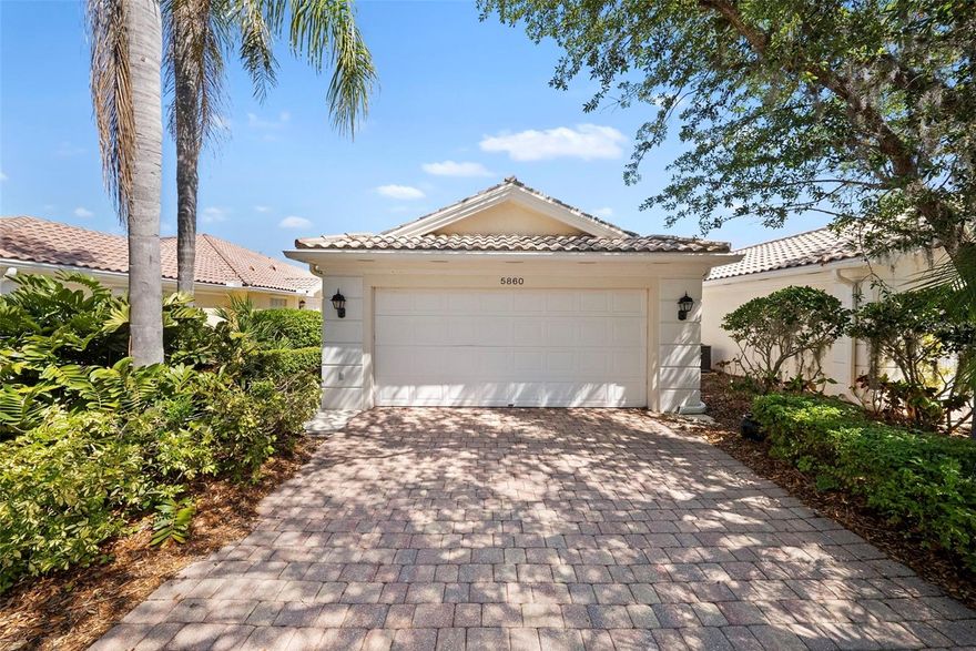 Welcome to this beautifully maintained Capri III Extended Villa, built by DiVosta Homes and designed for both comfort and an active lifestyle. This thoughtfully upgraded residence features durable tile flooring throughout the main living areas and engineered wood flooring in the bedrooms, combining style with easy maintenance. The open-concept layout includes a spacious great room with soaring vaulted ceilings, a dedicated dining area, and an inviting open kitchen highlighted by granite countertops and stainless-steel appliances—including newer microwave, range, dishwasher, and refrigerator. Step outside to your oversized screened lanai, recently rescreened and finished with a stamped patio surface, where you can relax and enjoy tranquil water views year-round. A separate laundry room with utility sink and built-in cabinetry adds everyday convenience. Located within the highly sought-after, gated community of VillageWalk, residents enjoy lush, beautifully landscaped grounds perfect for walking, biking, or cruising by golf cart. The community offers an unmatched array of amenities, including a clubhouse with state-of-the-art fitness center, library, and event space, along with six Har-Tru lit tennis courts, pickleball courts, bocce ball, and basketball courts. Relax in the resort-style geothermally heated pool or swim laps in the dedicated lap pool. VillageWalk’s Town Center features a full-service restaurant, boutique, hair salon, gas station, and a poolside tiki bar—bringing sun and fun right to your doorstep. With an onsite HOA manager and activities director, there’s always something to enjoy. Ideally located near the world-renowned Siesta Key Beach and with easy access to the Legacy Trail, as well as shopping, dining, and entertainment, this home truly offers the best of Florida living.