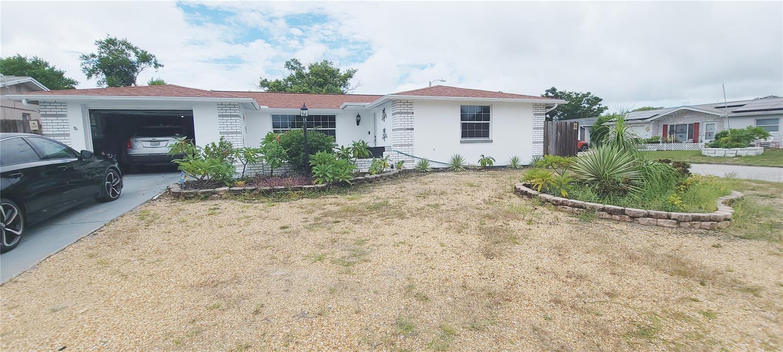 Picture a sun-drenched day just beginning for your family as you pull up to your new home in Port Richey. You had been looking for days, but the moment you saw the house on the fenced corner lot with its tropical landscaping, you knew the journey was worth it.
Inside, the house felt like a breath of fresh air. The open-concept living area welcomes you with tile floors and beachy colors that amplify the natural light streaming in. You marvel at the updated kitchen, with its gleaming stainless steel appliances and smooth exotic granite countertops. This would be the heart of the home, where countless family dinners and holiday meals would be prepared. The split-bedroom floor plan allows for privacy. Each room is a blank canvas for their new lives.
But the real magic was out back. The rear of the home opens to a large, enclosed lanai, a hallmark of Florida living. This is more than just a porch; it is a sanctuary where you can relax and enjoy yourself. A spacious open patio extends from the lanai to the pool area with a tiki bar and room for ample patio seating, and perfect for grilling and outdoor dining. The main attraction is a large, above-ground pool, always sparkling in the sunlight. You can immediately begin planning your summer days, imagining cannonballs and splash fights under the Florida sun. The fence surrounding the yard provided a sense of privacy and safety, ensuring your little slice of paradise is truly your own.
In the evening, you can gather on the lanai. As the sun begins to set, casting a warm orange glow across the sky, you can already see your future unfolding. This house is more than just three bedrooms and two baths; it is a home with a large lanai, an open patio, and an above-ground pool—a place where you could truly begin your new life.
