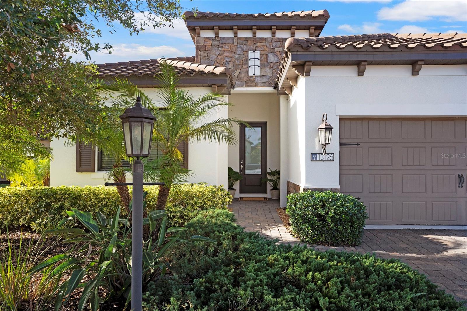 Welcome to your dream home at Indigo by Neal Communities. This furnished WINDSTAR floor plan sits on an oversize homesite with a long water view, offering nearly 2,900 square feet of living space. This thoughtfully crafted home features 4 bedrooms, 3.5 bathrooms and a versatile den/study. Upon entering, you'll be captivated by the expansive open layout, enhanced by breathtaking views of the pool and peaceful lake beyond. Enjoy picturesque sunsets every evening with the coveted southwest exposure. The elegant living room showcases coffered ceilings, double crown molding & recessed lighting. The kitchen in your new home is a chef's paradise! Featuring premium GE Profile stainless steel appliances, 42" upper cabinets, stunning stone countertops, and an exceptionally spacious walk-in pantry, a large island and a spacious kitchen-dining room combination. The master suite bathroom is a true retreat, offering two walk-in closets, a large soaking tub, 2 generously sized individual vanities, a convenient water closet with a spacious walk-in shower. The stylish laundry room includes a cabinet base wash tub and a matching GE Energy Star washer and dryer. Step outside to your private lanai, where a full-width pool deck invites you to relax. Take a dip in your heated salt water pool that is surrounded by lush palm trees, beautiful landscaping and a water view that creates your very own oasis. This 5-year-old home is equipped with natural gas for the pool heater, cooktop, dryer, and hot water heater. Your 3-car garage showcases quality features, including the builder's upgraded epoxy flooring and practical overhead storage racks. Enjoy peace of mind with Hurricane-Rated Impact Glass Windows and Sliders, designed to withstand storms while contributing to lower insurance rates and enhanced energy efficiency. Additionally, energy efficiency is further optimized with foam-injected concrete block walls and radiant barrier panels in the attic, complete with attic space flooring. Embrace a true maintenance included lifestyle in the sought-after neighborhood of Indigo. Here, residents have access to an impressive array of top-notch amenities. Our Amenity Center features a luxurious Clubhouse with a catering kitchen, a heated resort-style pool with cabanas, a Spa, a 24/7 fitness center, pickleball courts, bocce ball and a playground. The best part? All these amenities are expertly overseen by a dedicated full-time activity's director, ensuring a lively calendar of events and services for our residents—all for an affordable HOA fee. Don't let this extraordinary opportunity pass you by—make Indigo your home, where luxury, comfort, and convenience come together to elevate your everyday living!