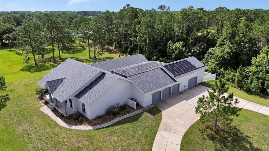 One or more photo(s) has been virtually staged. This estate property offers a rare combination of some of today’s most sought-after features; Set on over 2 acres in New Smyrna Beach. Designed for both entertaining and everyday living, the home features a chef’s kitchen that connects to expansive gathering spaces ideal for hosting family and friends. A private multi-generational suite adds flexibility for extended family, guests, or private living arrangements.
The pool courtyard creates a relaxing retreat complete with a spa, outdoor shower, and fenced dog run. Car enthusiasts, hobbyists, or those needing additional storage will appreciate the oversized 3-car garage and separate air-conditioned workshop space, with a 30-foot attic storage area with lift access directly from the garage.
Among many notable features, this home has no history of flooding. Additional upgrades and features include waterproof luxury vinyl plank flooring throughout the main living areas installed in 2023, a whole-home generator connected to a 500-gallon propane tank (owned), continuous-use gas water heater with a circulation system, temperature-controlled storage room, a 2024 roof and a solar pool heater installed in 2023. 
Conveniently located close to shopping, dining, and everything New Smyrna Beach has, this unique property combines acreage living with the functionality and features buyers are searching for today.
All information including measurements are intended to be accurate, but not guaranteed. Interested parties must verify all important information. Some photos have been virtually staged.
