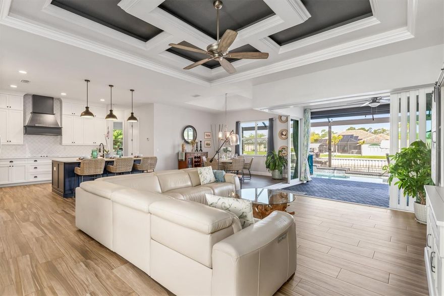 SIZE DOES MATTER! Get ready to fall in love with this amazing 2,443 SF waterfront home in the highly sought-after South Gulf Cove boating community, featuring 3 large bedrooms, 2 full bathrooms and office. A metal roof, Bahama shutters and automatic roll down shutters will give you convenience and peace of mind year-round.   The kitchen is equipped with quartz countertops, double-stack cabinetry, a huge hidden pantry, and SS appliances. The open concept living area features a beautiful, coffered ceiling and zero-degree pocket sliders. The spacious owner’s suite has direct lanai access and split walk-in closets. The master bath features a spa-like wet room design with a 3-head shower and freestanding tub enclosed behind sleek glass barn doors. Each of the large guest rooms has a walk-in closet. The full guest bath also acts as a convenient pool bath when entertaining. The laundry room is thoughtfully designed with a storage closet, utility sink, and additional cabinetry. The heated saltwater pool is surrounded by a generous paver lanai. There is a built-in outdoor kitchen and plenty of room for seating. Beyond the lanai is an irrigated and fully fenced St Augustine back yard that leads to the canal. There you will find a 30' dock, a 10K LB boat lift with canopy, newly wrapped pilings, an 80 ft. concrete seawall, and electric and water lines. The oversized three-car garage gives you plenty of space for vehicles, tools, toys, and storage. The garage also includes overhead storage, and the home is equipped with 50-amp power for generators. Beautifully maintained and full of sunny Florida charm, this move-in-ready home is also close to pristine beaches, world-class fishing, championship golf courses, wonderful restaurants, and great shopping. This beauty won’t last long—call me today for a private showing!