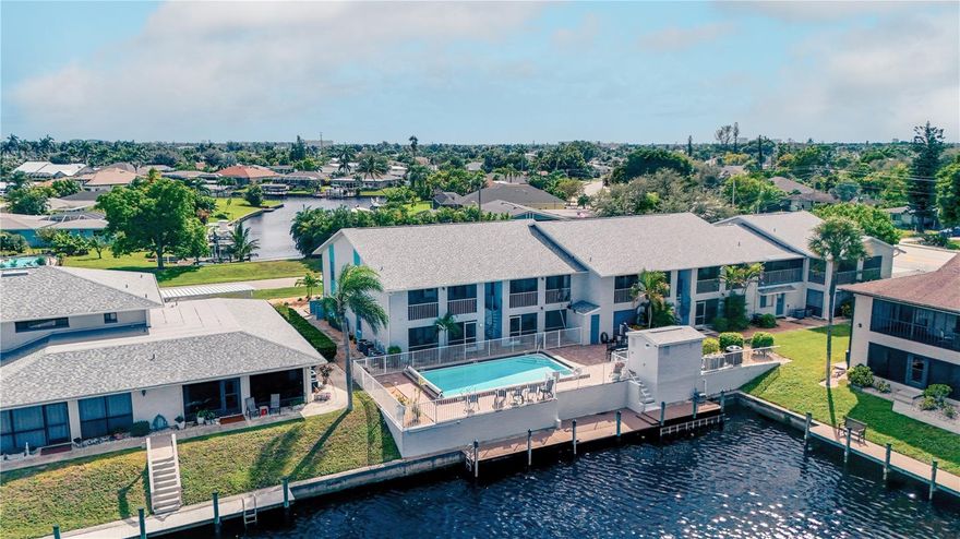 Light and bright end-unit condo in SE Cape Coral with stunning views of the pool and Gulf-access canal. This 2-bedroom, 2-bath home features wood-look tile throughout, solid surface countertops in the kitchen, and both a dining area and an eat-in space off the living room. Enjoy peace of mind with a newer A/C unit, new water heater, freshly painted exterior, full hurricane shutters enclosing the screened lanai, and a fully funded HOA with solid financials. The community offers a first-come, first-served Gulf-access dock, and condo fees include water, building insurance, and flood insurance. Washer and dryer are conveniently located in the unit—everything you need to enjoy the easy Florida lifestyle!