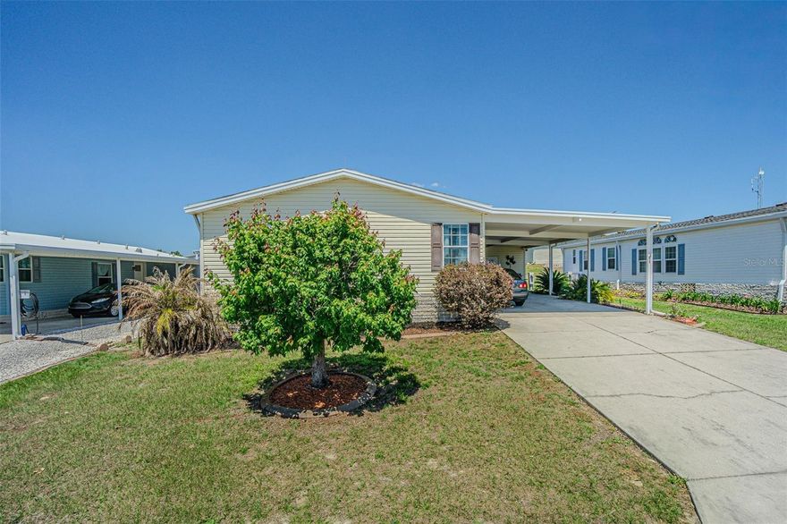 Welcome to Florida living in this beautifully maintained, Jacobsen manufactured home located in the desirable, gated 55+ community of Grand Horizons—where you OWN the land.  Extra wide driveway & extended carport can accomodate 6 cars on this high & Dry homesite! Offered FURNISHED, turn-key and truly move-in ready, this spacious 3-bedroom, 2-bath home features a split-bedroom floor plan with walk-in closets in every bedroom. The heart of the home is the bright, OPEN kitchen, complete with a center island, loads of cabinets, pantry, convection oven and all appliances, which is OPEN to a generous dining area perfect for entertaining.  Just off the kitchen, you’ll find a large indoor laundry room with washer, dryer, and an additional walk-in pantry. The expansive 25x14 great room at the rear of the home is a standout feature, offering a fireplace, baby grand piano and ample space for gatherings, with sliding doors leading to a fully enclosed, insulated, and air-conditioned Florida room—ideal for year-round enjoyment. The primary suite offers a private retreat with dual sinks, a walk-in shower with built-in seating, and a spacious closet, while the secondary bedrooms provide flexibility for guests or a home office. Upgrades include laminate floors throughout main areas, tinted windows, a newer central A/C with heat pump, water softener, and reverse osmosis filtration system. Outside, enjoy great curb appeal with brick paver accents, an oversized driveway and extended carport accommodating multiple vehicles, plus a 9x12 shed/workshop wired for 220. Ideally located less than a mile from shopping, dining, medical facilities, and entertainment, residents also enjoy an active lifestyle with community amenities including shuffleboard courts and a clubhouse with commercial kitchen, billiards room, craft room, library, resort-style pool and spa with onsite entertainment and travel excursions! This is your opportunity to enjoy comfort, convenience, and a vibrant community... just bring your suitcase and start living the Florida lifestyle you’ve been waiting for.  CALL TODAY!