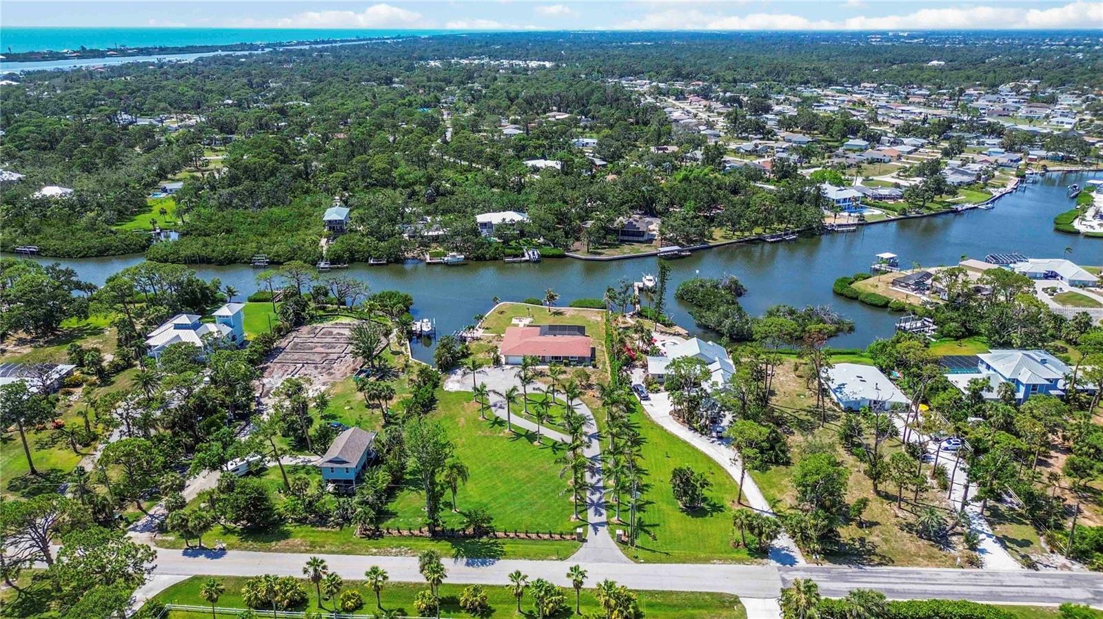 One or more photo(s) has been virtually staged. Coastal living at its finest! Welcome to 1475 Bayshore Drive — a beautifully maintained 3-bedroom, 2.5-bath canal-front home nestled on 1.25 acres of lush, manicured land. This private waterfront oasis features its own boat dock and lifts for both your boat and jet ski/kayak (lift capacity pending verification with manufacture of motor), with quick access to Lemon Bay, and the Gulf beyond. Enjoy the heated saltwater pool and spa, complete with a handicap-accessible lift, and soak in the panoramic views of the peaceful, mangrove-lined canal.
Unwind by the fire pit as the sun sets over the water, offering a truly tranquil atmosphere. The long, picturesque driveway creates a stunning first impression as you approach this well-positioned home. Whether you’re seeking a full-time residence or a seasonal escape, this property is a rare gem offering space, privacy, and the ultimate Florida lifestyle.