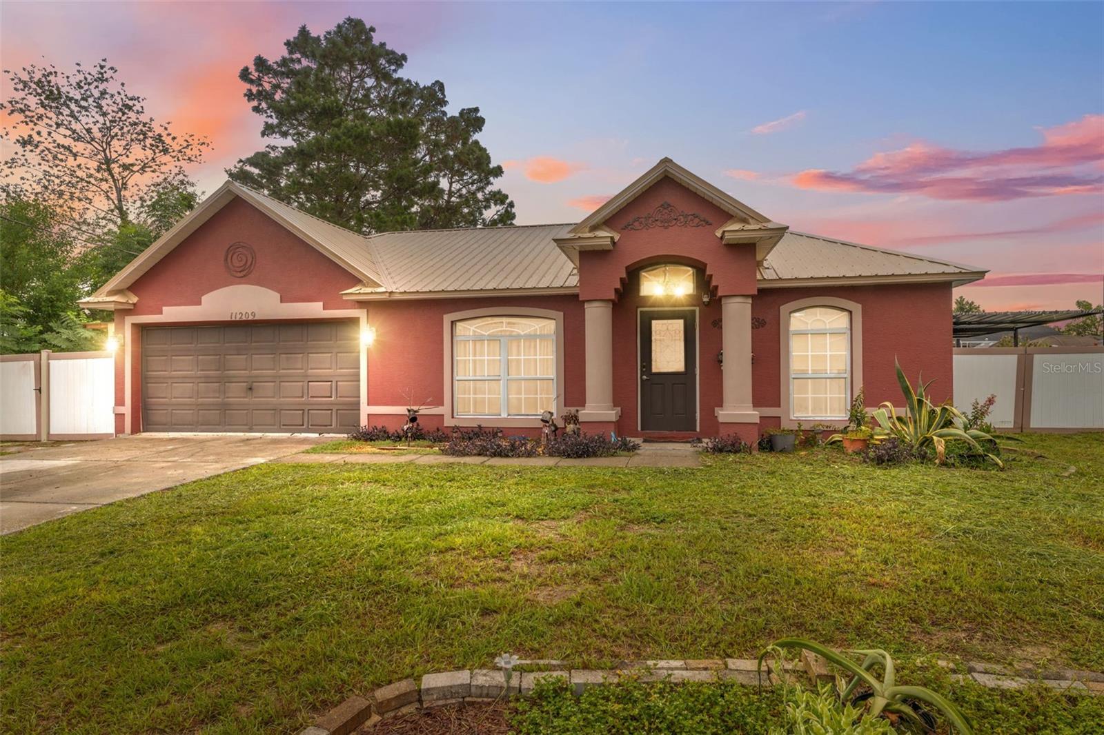 Step inside this beautifully maintained home featuring 3 bedrooms, 2 bathrooms, and an additional efficiency suite that provides endless possibilities for guests, extended family, or private workspace. A welcoming covered entrance opens into the foyer, where the kitchen sits to the left with granite counters, a center island with breakfast bar seating, a closet pantry, and a window-style opening that connects it to the spacious living room. Cathedral ceilings, a skylight, and elegant chandeliers bring warmth and light to the combined living and dining area, which flows seamlessly to the covered back patio through sliding glass doors. The primary suite offers bamboo flooring, a walk-in closet, and an ensuite bath with granite counters, an upscale sink, and a step-in shower, while the additional bedrooms each feature thoughtful details such as walk-in closets, stylish chandeliers, and matching upgraded finishes. The converted garage adds valuable living space with its own bedroom, bathroom, kitchenette, and laundry area. Outdoors, enjoy a caged pool, two storage sheds, a fenced yard with vinyl fencing, and an irrigation system that keeps the landscape lush. Recent updates include a 4-year-old metal roof for added peace of mind. This property is ideally located just 5 miles from Weeki Wachee Springs State Park, known for its crystal-clear waters, kayaking, and wildlife viewing, 8 miles from Hernando Beach, where you can enjoy waterfront dining and fishing, and only 7 miles from the Suncoast Expressway, providing direct access to Tampa and surrounding areas—making commuting simple while still being able to retreat to the peacefulness of home.