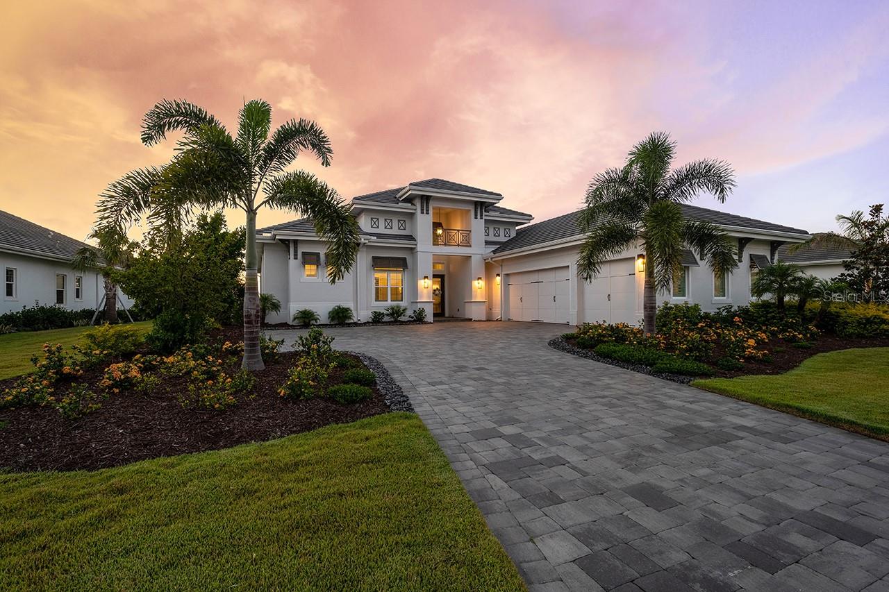 The perfect home awaits you in the highly sought after Lake Club community of Lakewood Ranch. Move right into this spectacular Stock Signature built Madison II ~ British West Indies home with four bedrooms, four and a half bathrooms on a private preserve lot with stunning sunset views.
The rock-lined paver driveway leads you to the front entrance welcoming you with double glass doors and a grand foyer. The home boasts impact windows and sliders throughout. Feel the expanse with the 15 foot tray ceilings in the Great Room, Dining Room, Study and Master Suite along with 12 foot sliders throughout the home allowing you to be surrounded with the beautiful Florida sunshine all while enjoying total privacy and tranquility on the oversized lanai with full panoramic views. Custom Plantation Shutters and motorized shades throughout the home.
The grand lanai hosts a 43” gas fireplace for those cool Florida evenings and a totally custom oversized outdoor kitchen with a built-in gas Artisan professional 36” 3-burner rotisserie grill with infrared single sear burner and griddle; built-in Coyote Asado Smoker Egg; double side burner; Artisan Refrigerator; stainless steel undercounter sink & pull-down faucet; Tradewinds 42” Hood; custom cabinets and granite countertops and oversized granite wall backsplash. The custom gas heated saltwater pool and spa with water feature offers a sunshelf, swim-out bench, autofill, entry steps and LED lights in pool & spa. The pool bath has a convenient entrance from the lanai perfect for your pool guests.
The gourmet kitchen offers a grand center island, quartz countertops, glass backsplash, undercounter lighting, pantry with ventilated wood shelving, custom cabinetry and upgraded Kitchen Aid appliances. Whole house Aqua Solar Water Softener Treatment System with transferrable Warranty. The Study has glass French doors and tray ceiling perfect for your home office or private library. Retreat to the master suite in the expansive bedroom and sitting area with French doors leading to a private section of the lanai. The two walk-in closets boast wood ventilated shelving. The master bathroom is bright and airy with a spa-like tub, two sinks with quartz countertops and walk-in shower with custom tile.
Each guest bedroom is an en-suite and the additional bedroom in the back of the home is a great extra bedroom or media room with private sliders to the lanai and access to the pool bath. The laundry room has the washer, dryer, utility sink, quartz countertops and extensive cabinetry. Two zone AC and heating system with a transferrable 10-year Labor Warranty. UV Dual Kit / Halo has been installed on AC Unit. Ceiling fans keep every room in the home and the lanai cool. The 3-car garage is side-loading with pull-down stairs to the walk-up attic over the garages. No CDD.
The Lake Club is a private gated community with a 20,000 square foot Grande Clubhouse featuring indoor and outdoor dining, spa & fitness center and resort-style swimming pool and family pool. Enjoy the tennis courts, pickleball courts, children’s playground, dog park, yoga lawn and basketball court. Just a short drive to beautiful downtown Lakewood Ranch, Waterside, UTC Mall and the Gulf Beaches.
