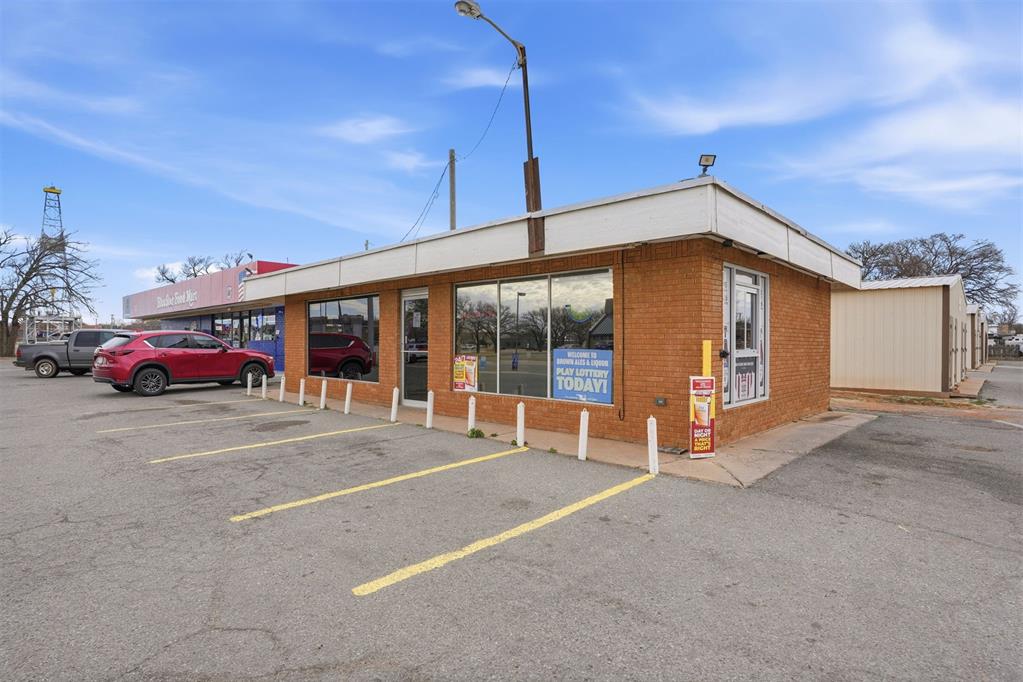 View of commercial property with parking and a convenient drive through.