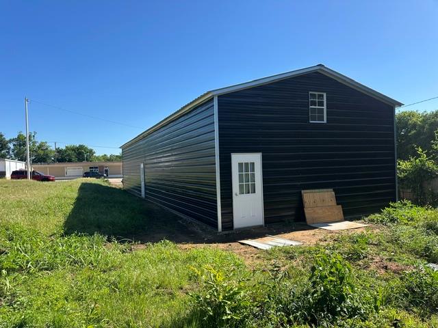 Metal-sided structure with a gabled roof and a single-pane window