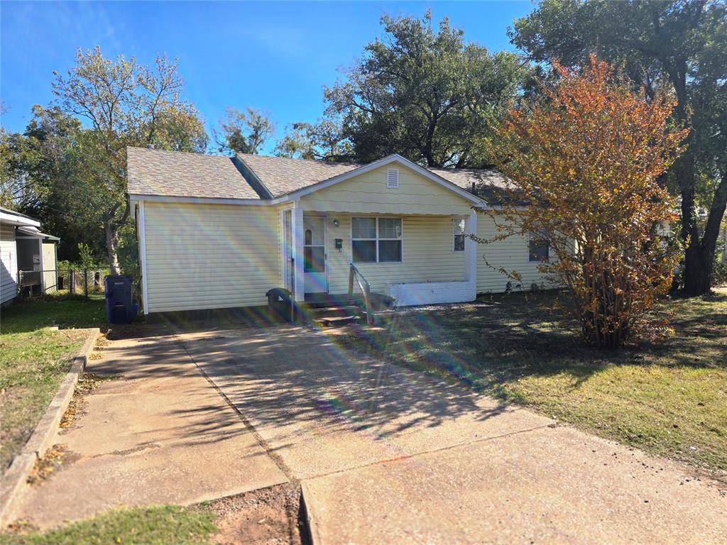 View of front of house with roof with shingles and a front yard