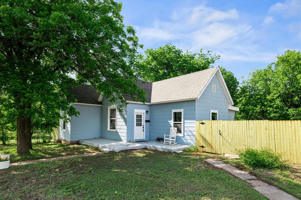 Light blue siding exterior with a white front door and multiple windows