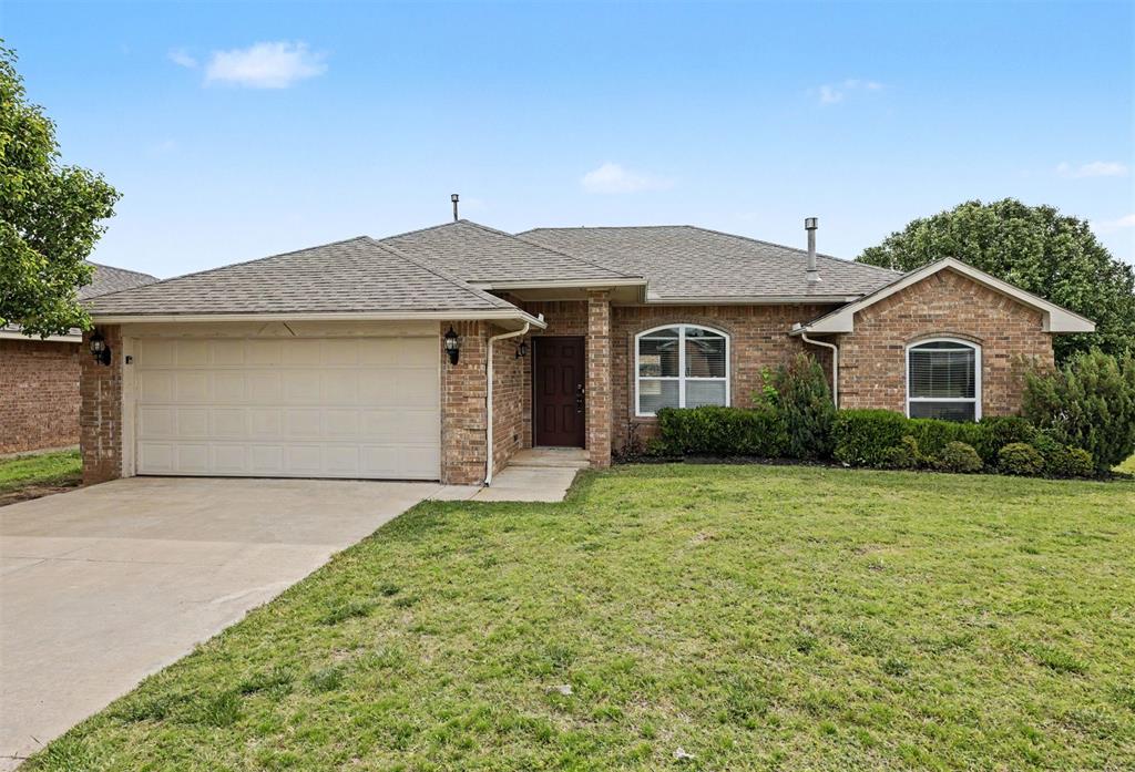 Brick exterior residence featuring a gabled roof and attached two-car garage