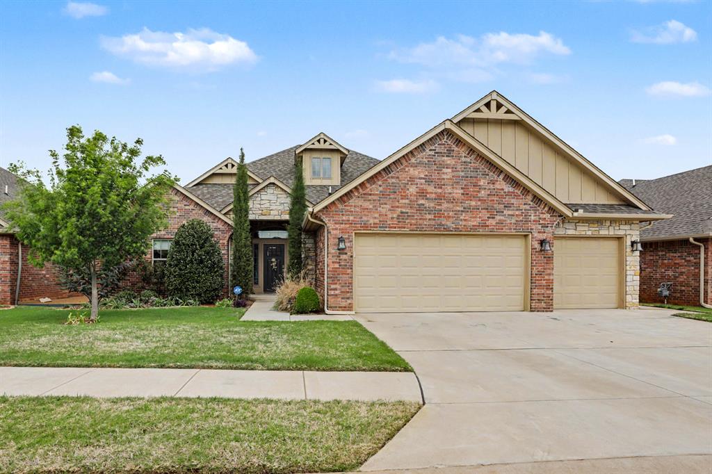 The property showcases a brick and stone exterior, a two-car garage, a well-maintained lawn, and mature landscaping