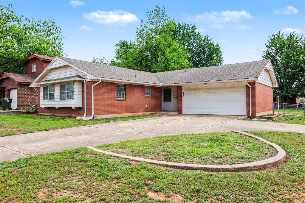 Brick exterior featuring a two-car garage and a concrete driveway