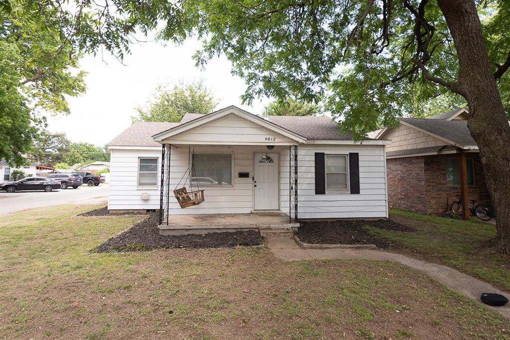 White siding exterior with a covered porch featuring black metal supports
