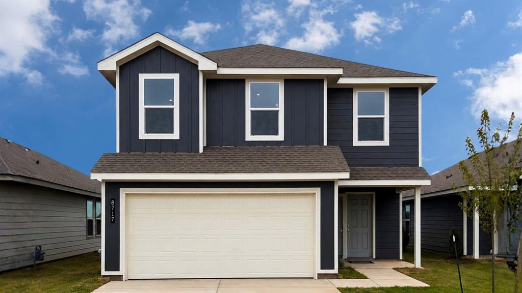 View of front of property with an attached garage, brick siding, driveway, and roof with shingles
