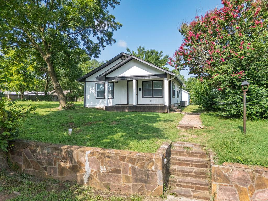 White exterior with dark trim and a covered porch