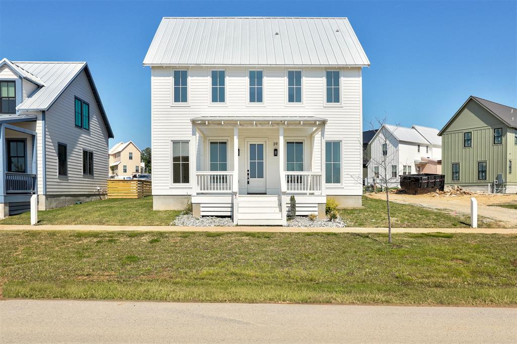 White two-story residence featuring a metal roof, horizontal siding, and a front porch with white railings