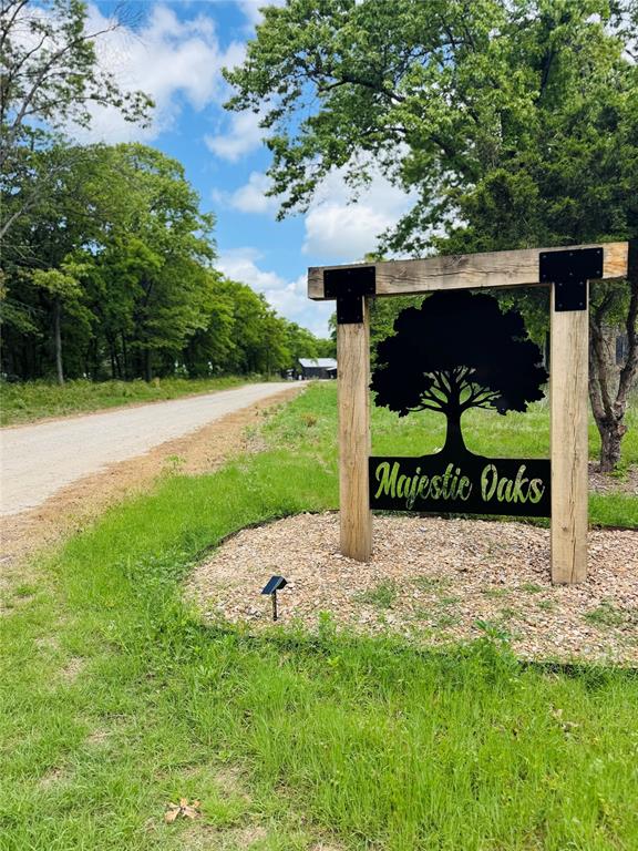 Wood-post entrance sign with metal scrollwork detailing