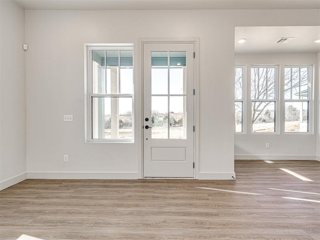 Doorway to outside with wood finished floors and recessed lighting