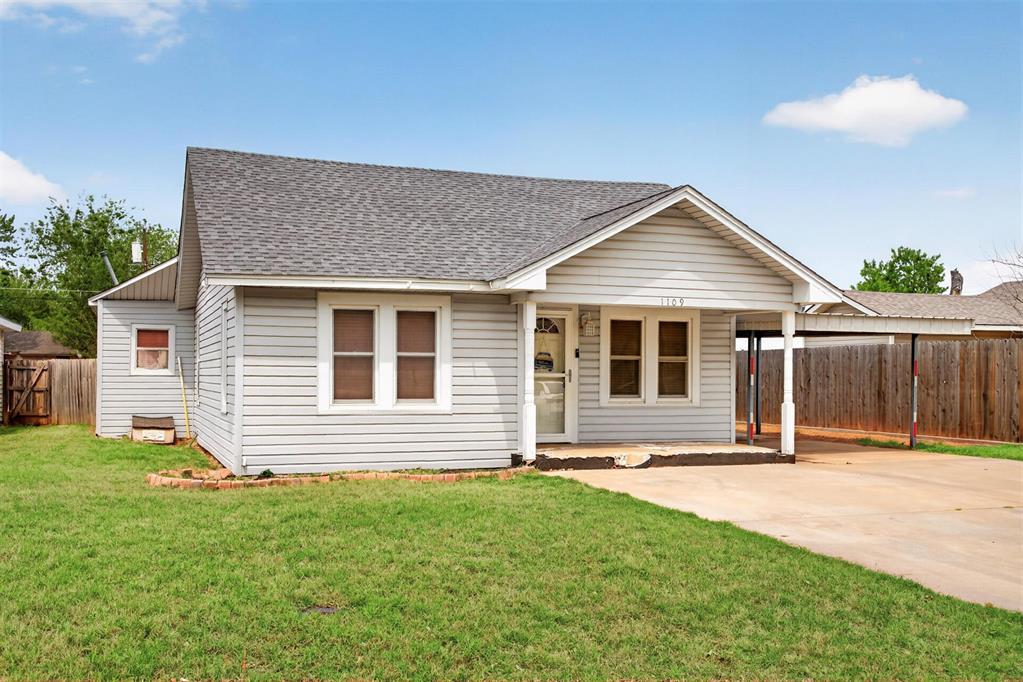 The property features a grey-sided exterior with white trim windows and a grey shingle roof