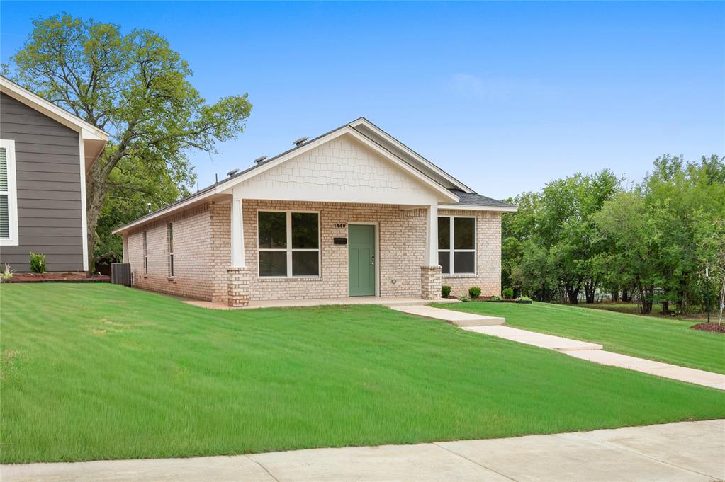 View of front of house featuring brick siding, a porch, and a front yard