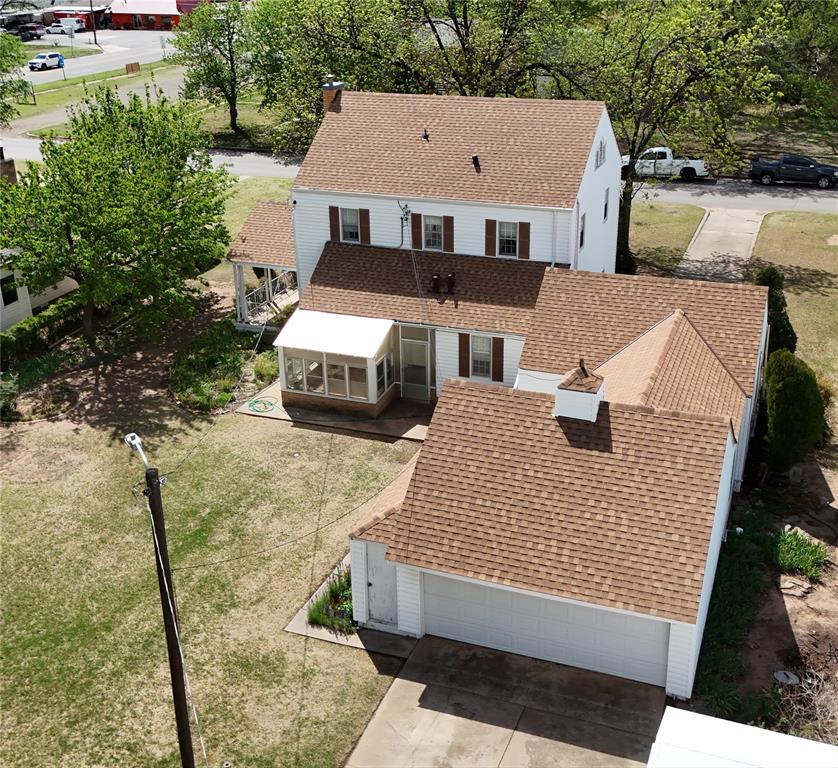 This property features a multi-level structure with a gabled roof, an enclosed porch, and a dedicated garage space