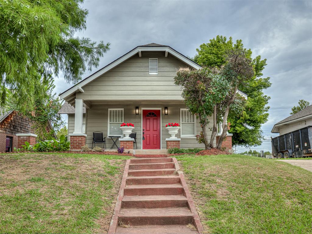 Bungalow-style home featuring brick siding, a front lawn, and a porch