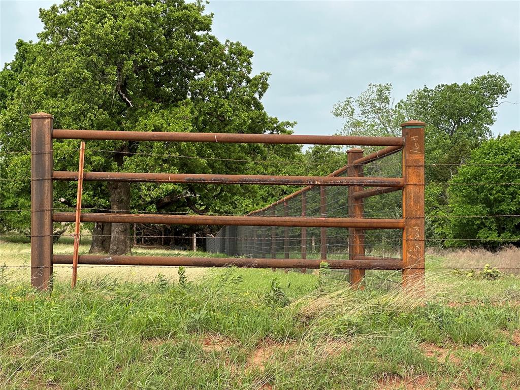 Rustic metal fencing featuring horizontal pipe rails and mesh infill
