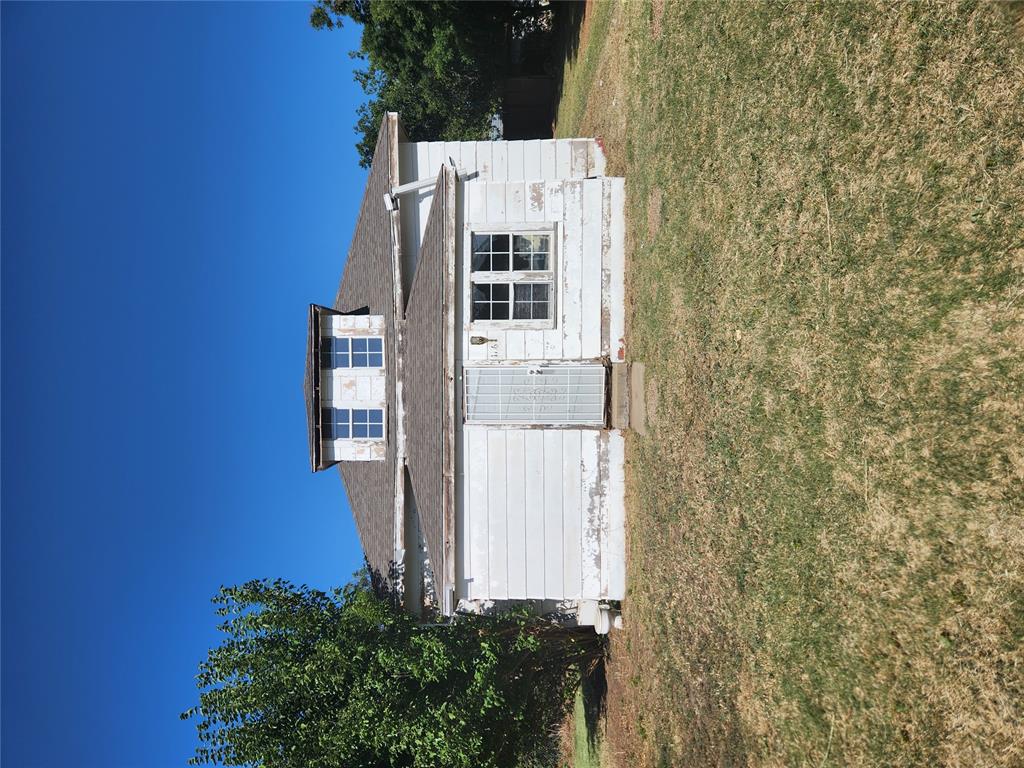 Fenced structure featuring a dormer window, mature trees, and a spacious lot
