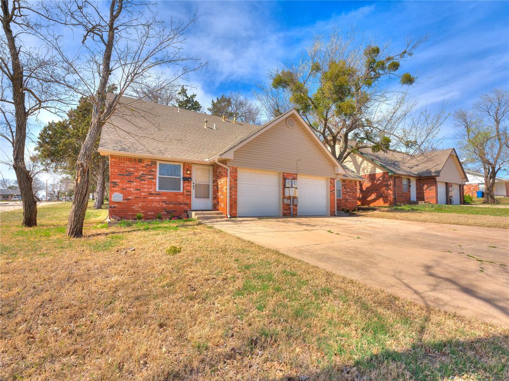 Ranch-style house with brick siding, a front yard, an attached garage, driveway, and a shingled roof