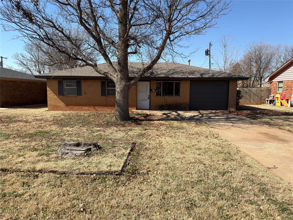 Ranch-style house featuring a garage, concrete driveway, brick siding, and roof with shingles