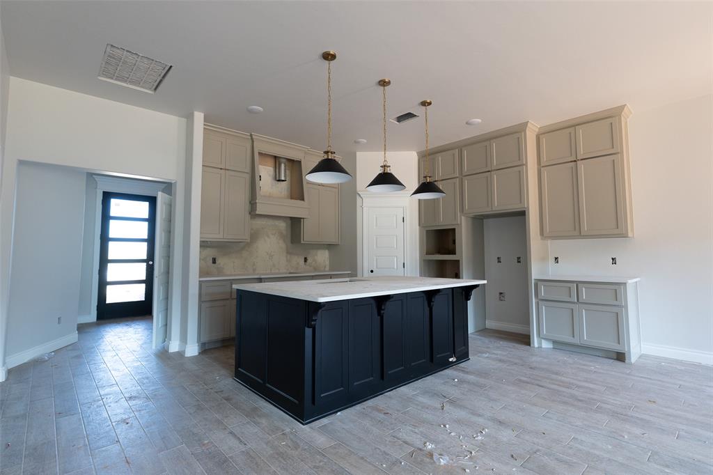 Spacious room under construction featuring exposed wood framing, multiple large windows, a double-door entryway, and a built-in fireplace