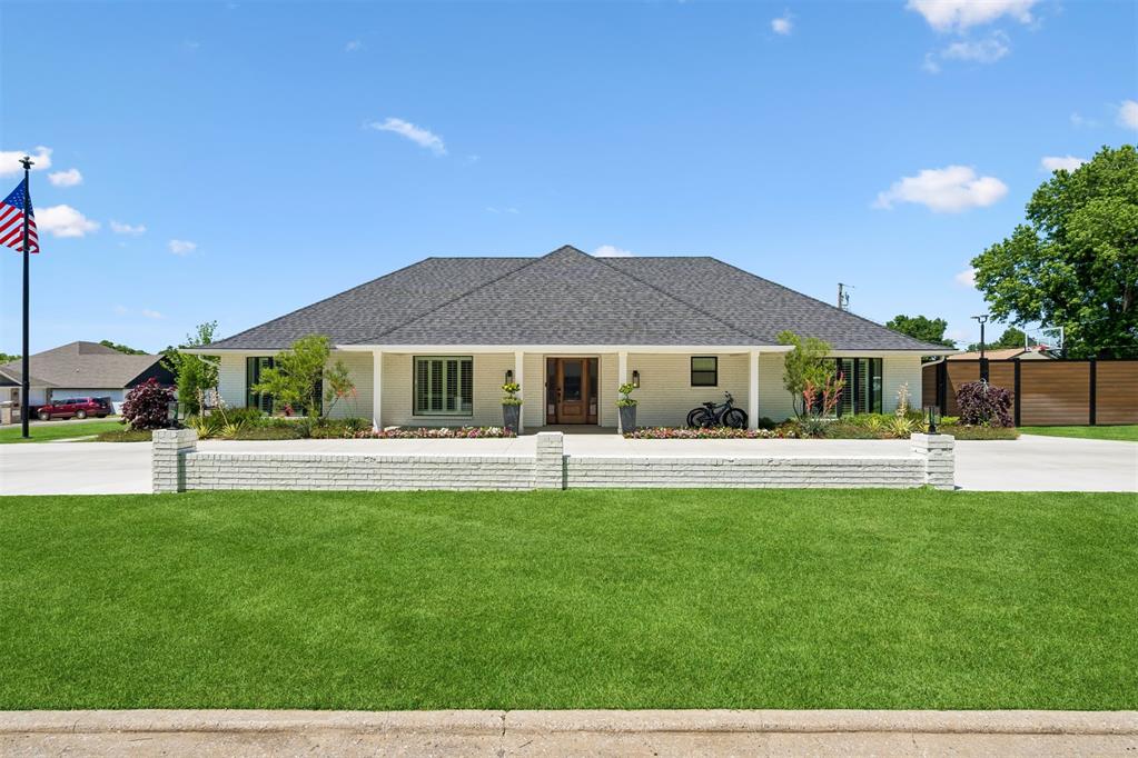 Contemporary single-story residence featuring a dark shingle roof and white brick exterior