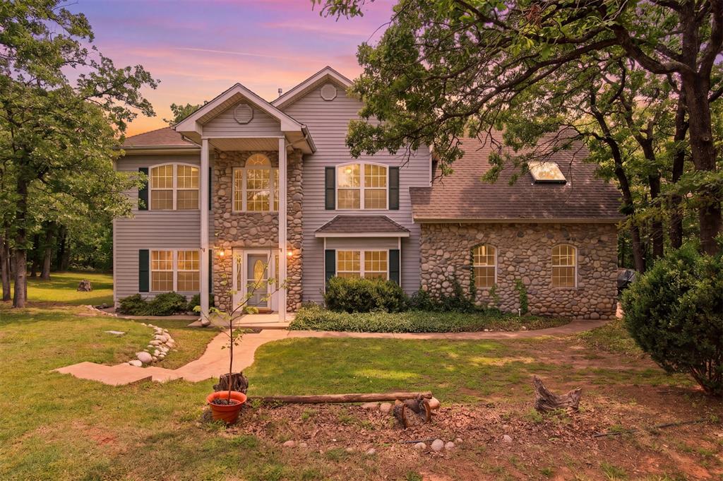Two-story residence featuring a stone and siding exterior
