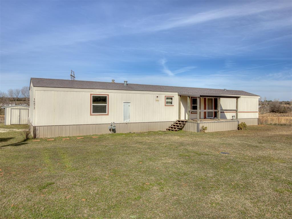 Manufactured / mobile home featuring a front yard and roof with shingles