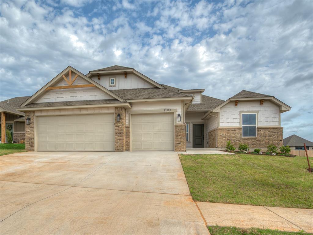 Craftsman-style house with a shingled roof, a garage, concrete driveway, brick siding, and a front yard