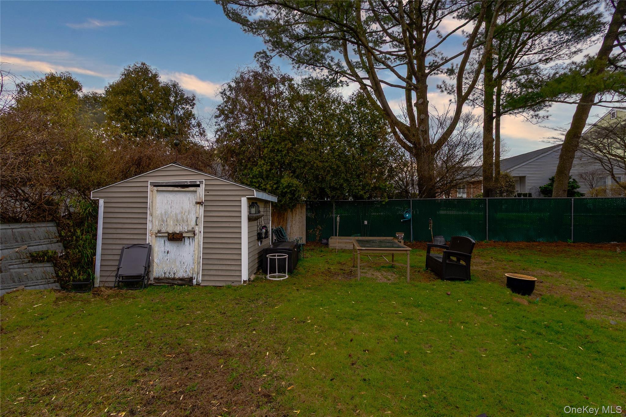 Yard at dusk featuring a fenced backyard and a storage shed