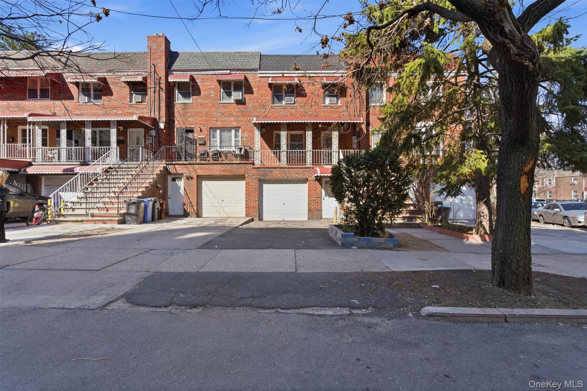 View of front of home with brick siding, an attached garage, driveway,
